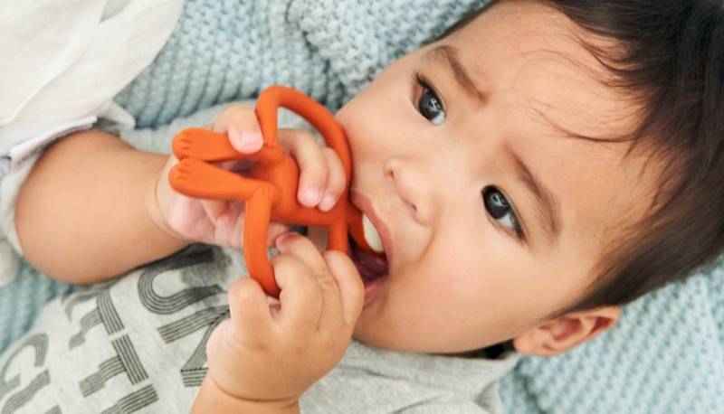 Baby boy chewing on a Matchstick Monkey teether