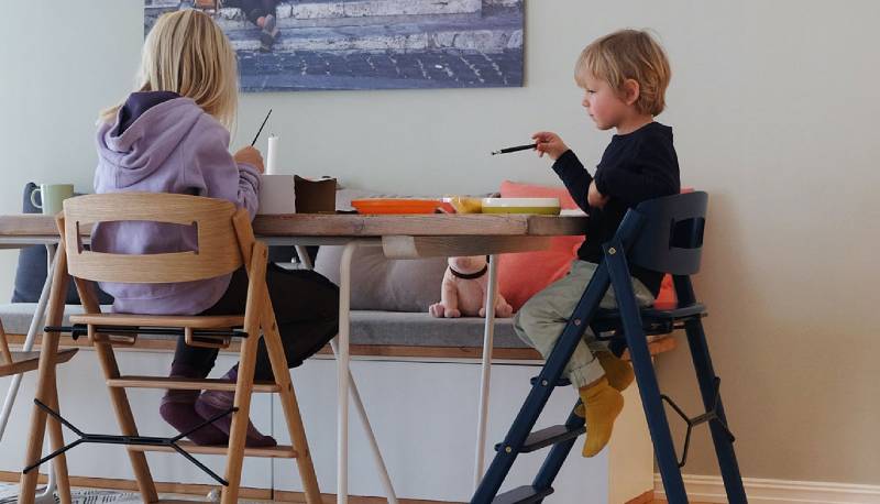 Two kids sitting in the KAOS Klapp Foldable Highchairs