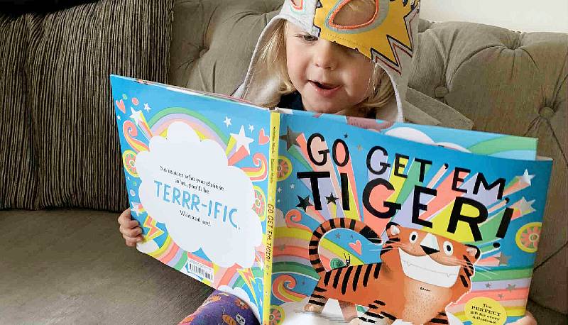Little girl reading Go Get Em Tiger