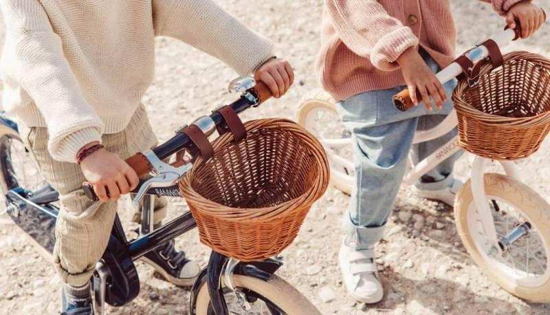 Two kids holding handlebars of Banwood bikes