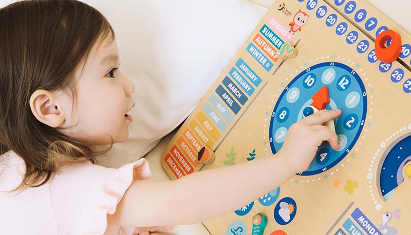Little girl plays with Classic World's Forest Calendar